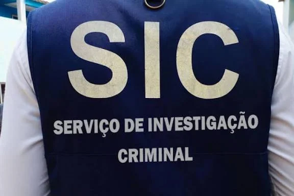 De acordo com uma nota de imprensa enviada hoje ao Jornal OPAÍS, as detenções ocorreram nos dias 6 e 10 de Fevereiro, no âmbito da estratégia de “pureza interna” levada a cabo pelo órgão, após denúncias formalizadas. O primeiro caso envolve um efectivo afecto ao SIC do Cuanza Norte, acusado de ter efectuado disparos de arma de fogo no interior de um estabelecimento comercial, no município do Cazenga, em Luanda. O incidente, ocorrido no dia 1 de Fevereiro, resultou em ferimentos num cidadão nacional, que foi prontamente socorrido. A arma utilizada na acção foi apreendida pelas autoridades. O segundo detido, afecto ao SIC de Icolo e Bengo e que exercia a função de chefe do Departamento de Investigação Criminal no município do Cabo Ledo, é acusado de envolvimento na invasão de terrenos no município do Calumbo. A detenção ocorreu após uma denúncia tornada pública nas redes sociais e posteriormente confirmada pelas autoridades. No momento dos factos, três outros indivíduos terão sido retidos pela população durante uma contenda relacionada com a ocupação de terrenos.
